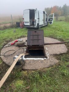 Průmyslová studna u Agro-Družstva Těmice před odborným čištěním – dno pokryté silnou vrstvou bahna a písku, omezený přítok vody.