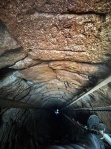 Ruční čištění historické kopané studny z roku 1875 – odstranění nánosů a sedimentu ze stěn.