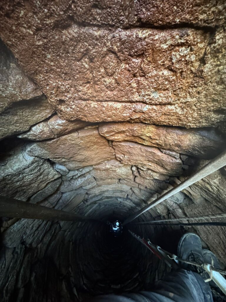 Ruční čištění historické kopané studny z roku 1875 – odstranění nánosů a sedimentu ze stěn.